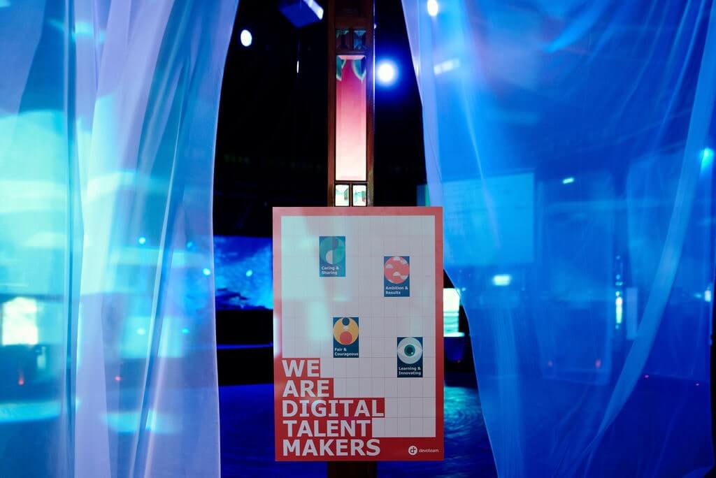 Scène d'une plénière d'entreprise éclairée en bleu, grand écran allumé derrière les intervenants, photographe événementiel Paris