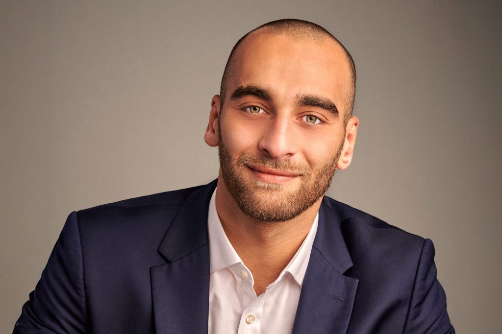 Portrait corporate d'un homme souriant en costume bleu marine, par Pierre-Yves Queignec, photographe corporate à Paris.
